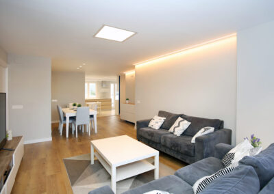 salon con dos sofas comunicado con cocina