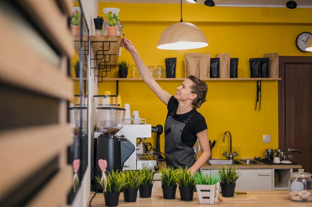 barista organizando estanteria cafeteria ambiente acogedor