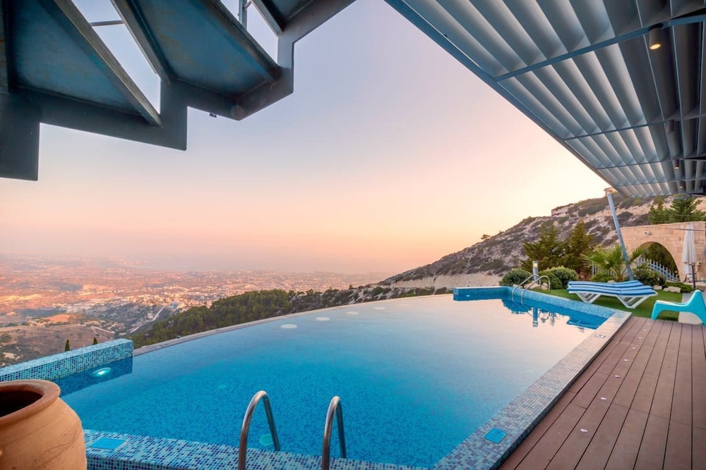 vista de piscina infinita en terraza con paisaje de montanas al atardecer